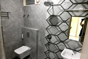 a bathroom with a toilet and a sink and a mirror at SR Grand in Tumkūr
