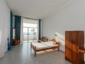 a bedroom with a bed and a large window at Kavin Beach Hotel Hikkaduwa in Hikkaduwa +99 photos