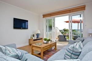 a living room with two couches and a tv at 3 Goodrington Lodge, Paignton in Paignton