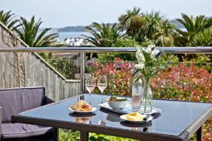 a table with food and wine glasses on a balcony at 3 Goodrington Lodge, Paignton in Paignton