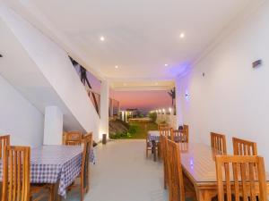 a dining room with wooden tables and chairs at Kavin Beach Hotel Hikkaduwa in Hikkaduwa