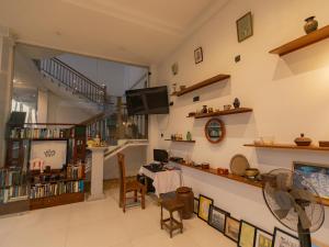 a living room with a tv and a table and chairs at Kavin Beach Hotel Hikkaduwa in Hikkaduwa