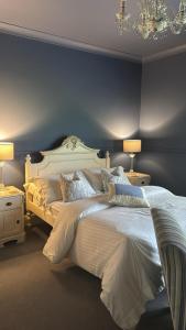 a bedroom with a large bed with blue walls at Plas Y Dderwen Bed and Breakfast in Aberystwyth