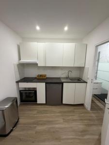 a kitchen with white cabinets and a sink at STUDIO deux NEUF A CROSNE in Crosne