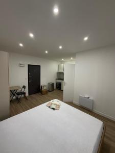 a white room with a bed and a kitchen at STUDIO deux NEUF A CROSNE in Crosne