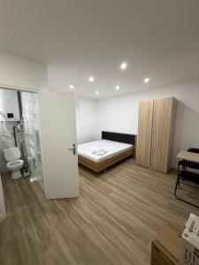 a room with a bedroom with a bed and a toilet at STUDIO deux NEUF A CROSNE in Crosne