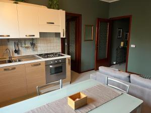 a kitchen and living room with a couch and a table at Pegaso - bilocale a pochi passi dal centro in Pordenone