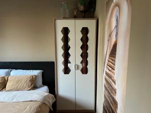 a bedroom with a white cabinet next to a bed at Pegaso - bilocale a pochi passi dal centro in Pordenone