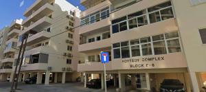 a building with a parking lot in front of it at Sunset Poolside Apartment with Pool facility in Larnaca +2 photos