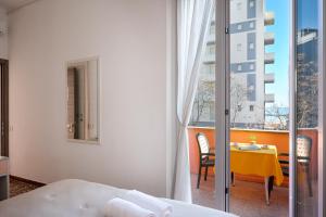 a room with a bed and a table and a window at Amadei Hotel Blumen in Pesaro