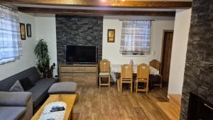 a living room with a couch and a table at Chaty Slovensky Raj Veronika in Smižany +4 photos