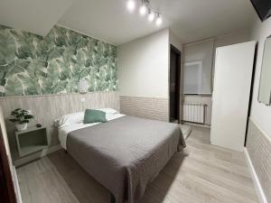 a bedroom with a bed and a wall with plants at Verdemar Rooms in Gijón +69 photos