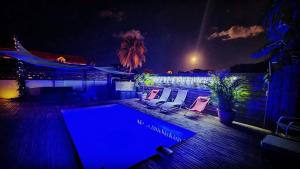 a swimming pool at night with two chairs and a swimming pool at Gîtes l'orée Bleue in Sainte-Rose
