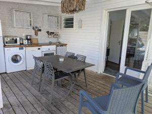 a kitchen with a table and chairs on a patio at Gîtes l'orée Bleue in Sainte-Rose +4 photos