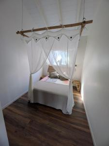 a bedroom with a bed with a canopy at Gîtes l'orée Bleue in Sainte-Rose