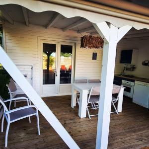 a porch with a white table and chairs on it at Gîtes l'orée Bleue in Sainte-Rose