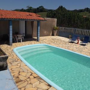 a swimming pool in a yard with a house at Chalé Romântico in Extrema