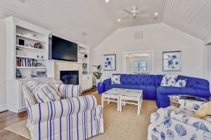 a living room with blue couches and a fireplace at Frankly My Dear - Duck, Oceanfront, Elevator, Wheelchair Friendly, Pool Table, Pool, Hot Tub, Flex Stays in Duck
