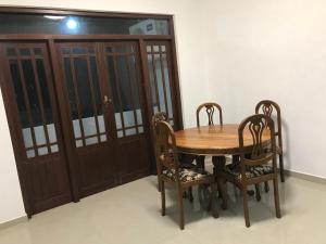 a wooden table with two chairs and a wooden cabinet at Slayan properties in Gampaha +6 photos