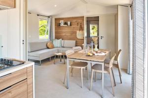a kitchen and a living room with a table and chairs at Oasis des Garrigues in Vogüé