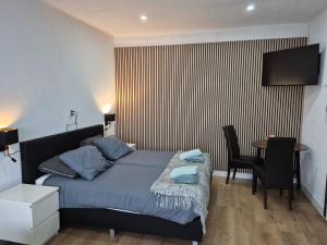 a bedroom with a bed and a table with chairs at Studio Slijterij Zandvoort in Zandvoort