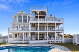 a large house with a pool in front of it at Frankly My Dear - Duck, Oceanfront, Elevator, Wheelchair Friendly, Pool Table, Pool, Hot Tub, Flex Stays in Duck