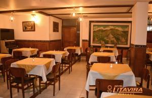 a restaurant with tables and chairs and a painting on the wall at Hotel Litavira Vintage in Sogamoso