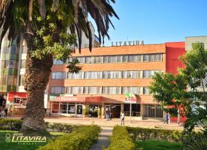 a building with a palm tree in front of it at Hotel Litavira Vintage in Sogamoso