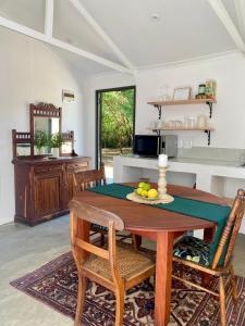 a dining room with a wooden table and chairs at Desert Bloom Cottage in Buffelskloof