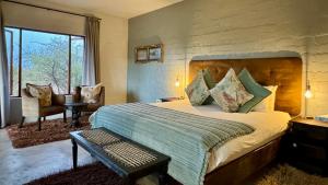 a bedroom with a large bed and a large window at River Crossing Lodge in Windhoek