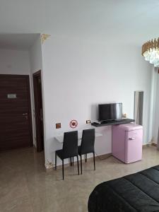 a kitchen with two chairs and a table with a microwave at La sirena in Mazara del Vallo