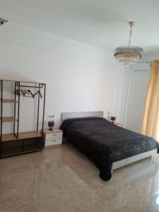 a bedroom with a black bed and a chandelier at La sirena in Mazara del Vallo