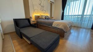 a bedroom with a bed and a chair and a window at Aspen Golf Resort Studio E206 in Bansko +21 photos
