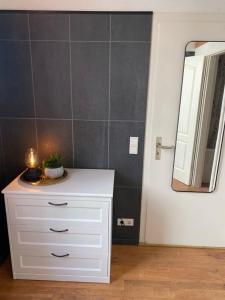 a bathroom with a white dresser and a mirror at Modernes City-Apartment in Krefeld - BEUYS Apartments Krefeld in Krefeld