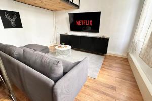 a living room with a couch and a tv at Modernes City-Apartment in Krefeld - BEUYS Apartments Krefeld in Krefeld