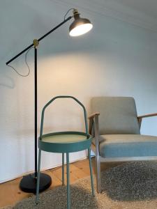 a lamp and a table and a chair in a room at Modernes City-Apartment in Krefeld - BEUYS Apartments Krefeld in Krefeld +9 photos