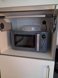 a microwave oven sitting on top of a cabinet at Appartment am Fingerhut in Cloppenburg