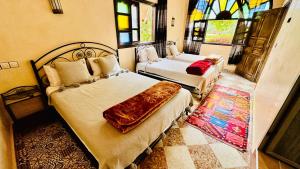 a bedroom with two beds and stained glass windows at Chez Ali Zagora Authentic Hotel Restaurant and Desert Excursions in Zagora +61 photos