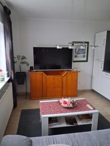 a living room with a tv and a coffee table at Appartment am Fingerhut in Cloppenburg