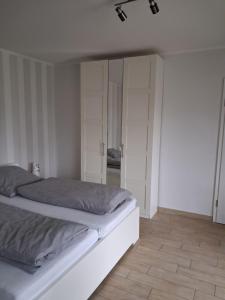 a bedroom with a white bed and a closet at Appartment am Fingerhut in Cloppenburg