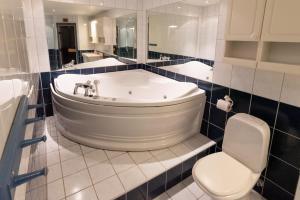 a bathroom with a white tub and a toilet at Bakkebyvegen 22A in Trysil +11 photos