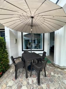 a table and chairs under a large umbrella at Casa Los Mangos 4 Piscinas 6 Camas y mucho Sol in Flandes