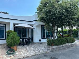 a house with a table and an umbrella on a patio at Casa Los Mangos 4 Piscinas 6 Camas y mucho Sol in Flandes