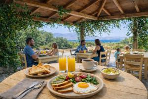 Eine Gruppe von Menschen sitzt an einem Tisch mit Eiern und Toast. in der Unterkunft Studios Vrettos Beachside Hotel in Plaka + 99 Fotos