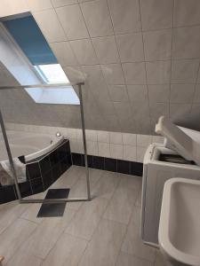 a bathroom with a bath tub and a sink at Maisonette with large terrace in Leipzig +14 photos