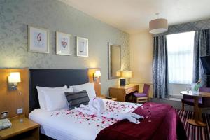a hotel room with a bed with two swans on it at Carlisle Station Hotel, Sure Hotel Collection by BW in Carlisle