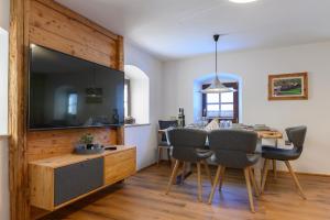a dining room with a large television and a dining table at Traunreiter Apartment in Bad Goisern