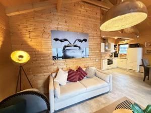 a living room with a white couch and a kitchen at Sky-View Chalet am Waldsee in Rieden