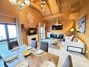 a dining room and living room with a table and chairs at Sky-View Chalet am Waldsee in Rieden