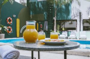 a table with a plate of food and two glasses of orange juice at Deco Collection in Buenos Aires